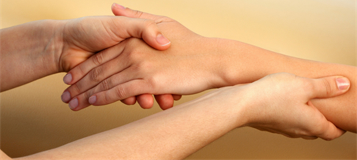 closeup of hands massaging a person's arm