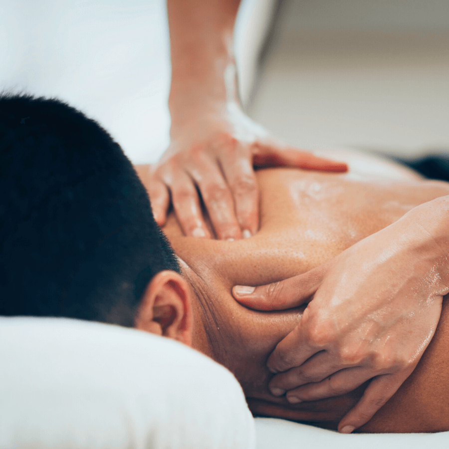 massage therapist hands massaging client's back
