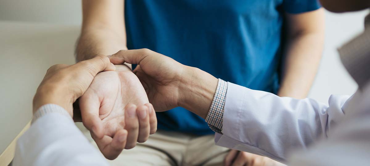 Massage therapists hands on client's wrist palpating