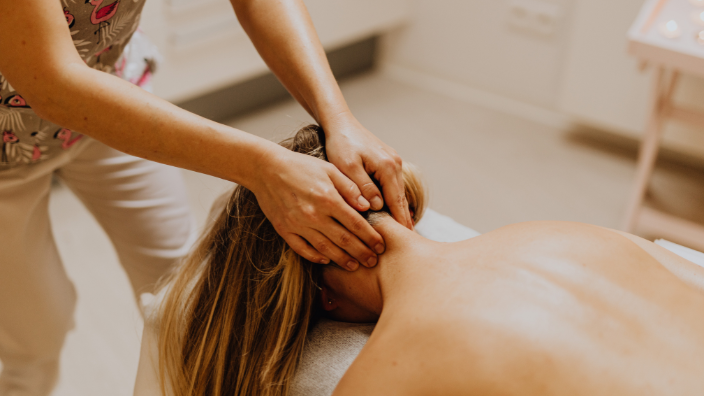an image of a woman receiving a neck massage.