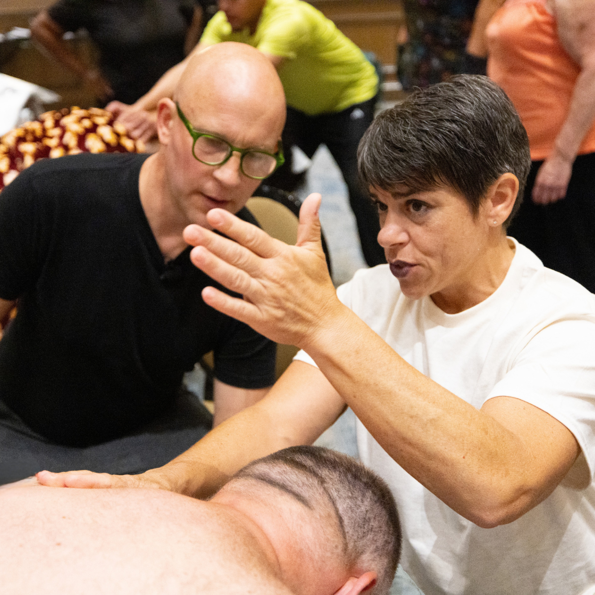 an image of a massage instructor showing a student a technique.