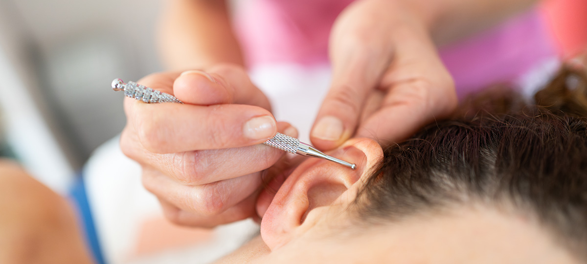 a close-up image of someone getting an ear massage.