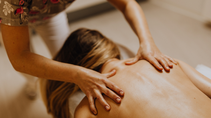 An image of a woman receiving a back massage.