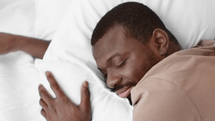 an image of a man sleeping and smiling.