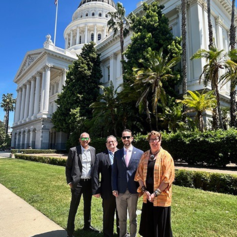 an image of a group of people in front of the California state capitol building.