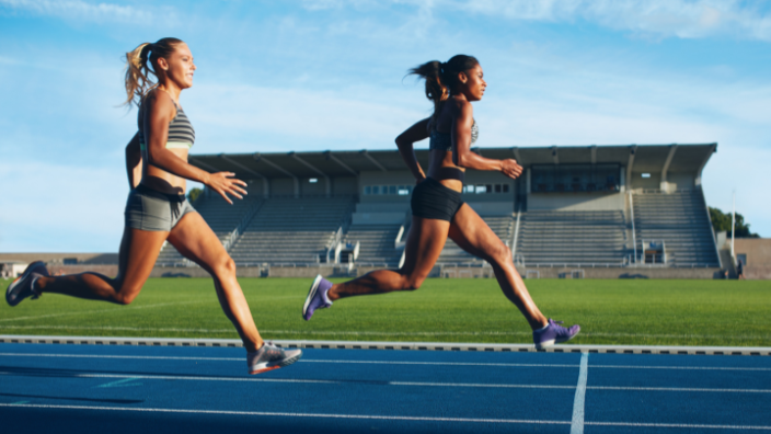 an image of two women running on the track.