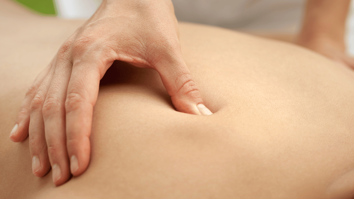 a close-up image of a hand massaging a back.