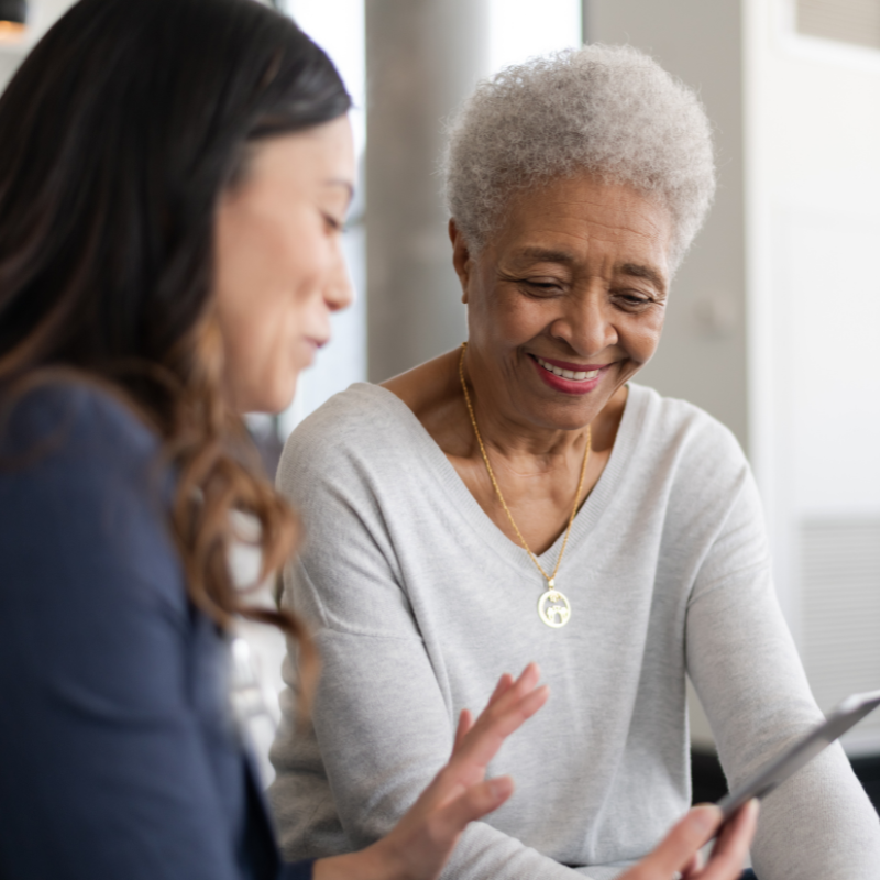 an image of an elderly lady smiling and talking to someone.