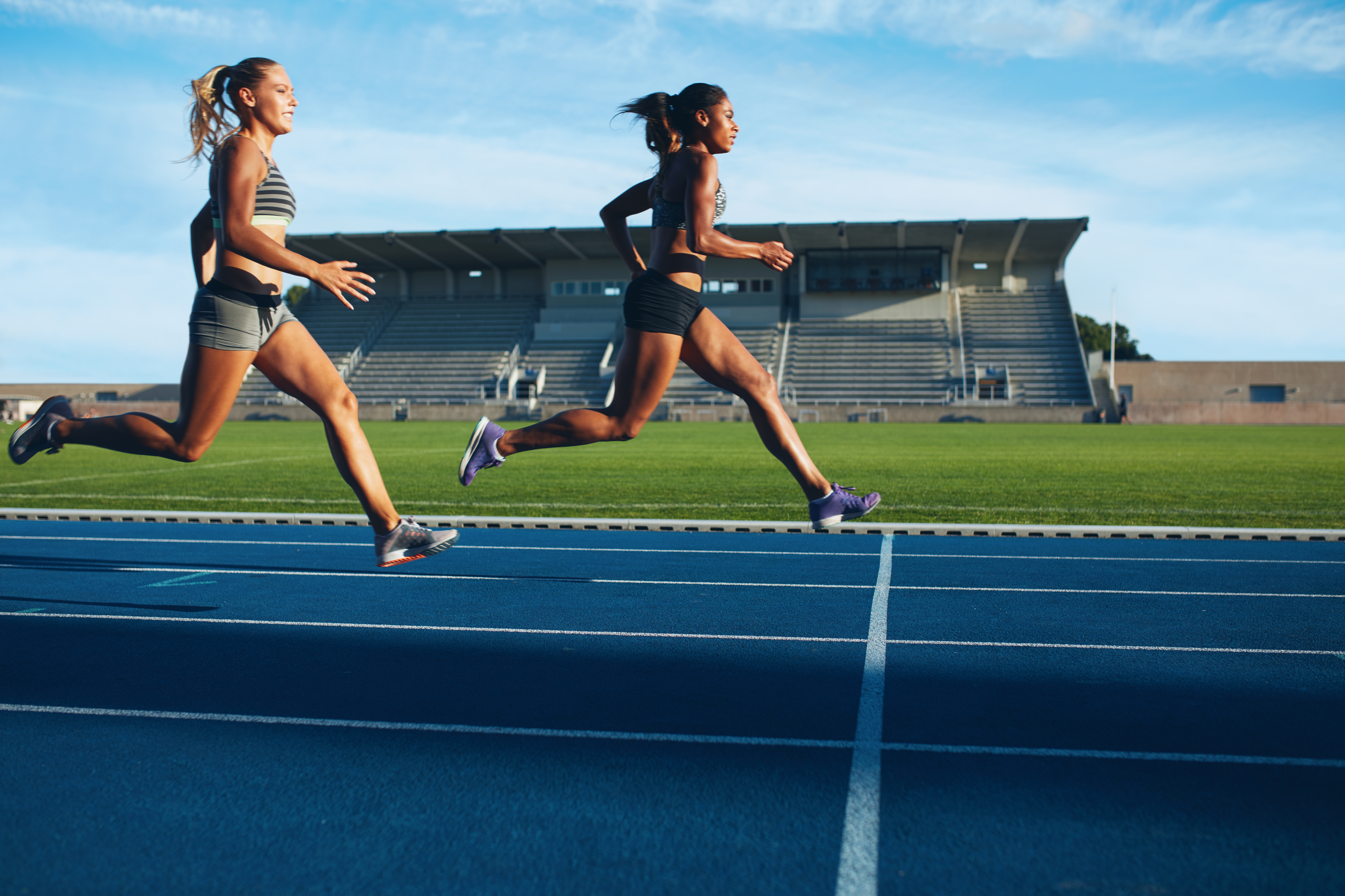 an image of two women running on a track