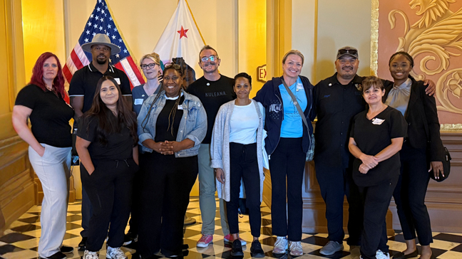 a photo of a group of people smiling in a government building.