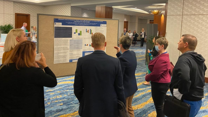 an image of a group of people talking about a research poster.