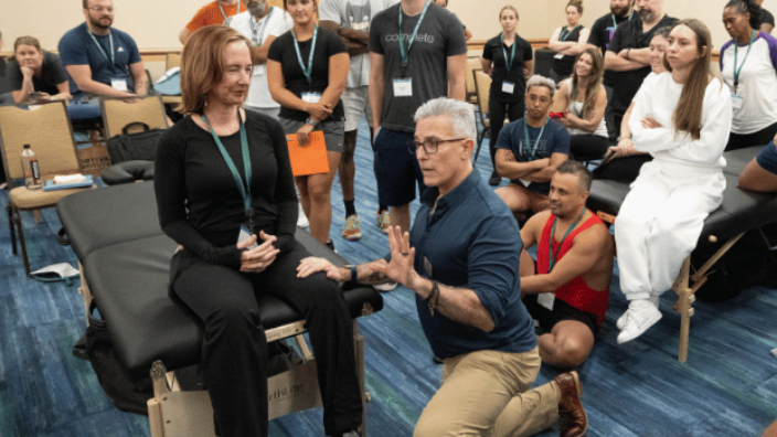 an image of a massage educator demonstrating a technique at an AMTA Convention.