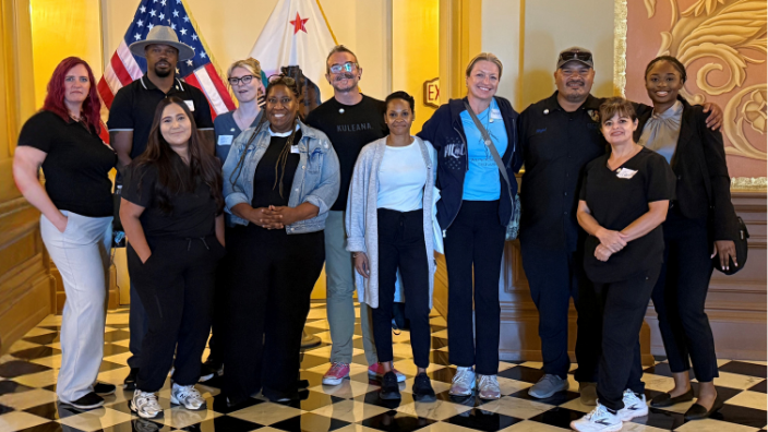a photo of a group of people smiling in a government building.
