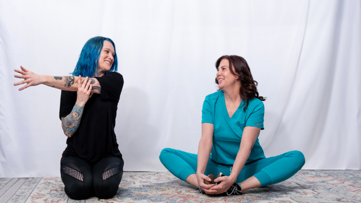 an image of two massage therapists stretching.