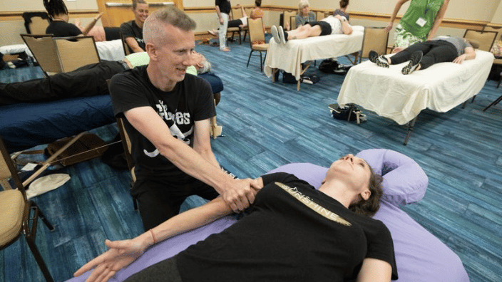 an image of a massage therapist performing fascial therapy on a client.
