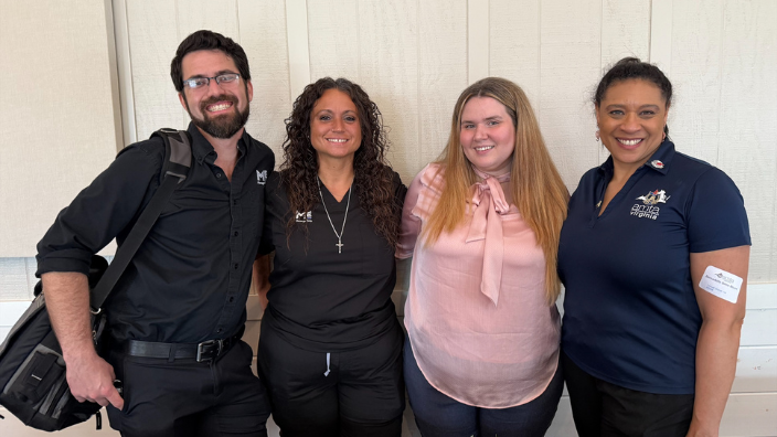 An image of four individuals at the VA AMTA Chapter Conference, one man and three women