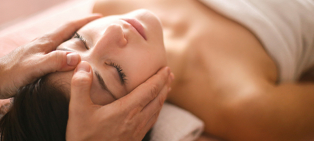 massage therapist's hands massaging female client's shoulders