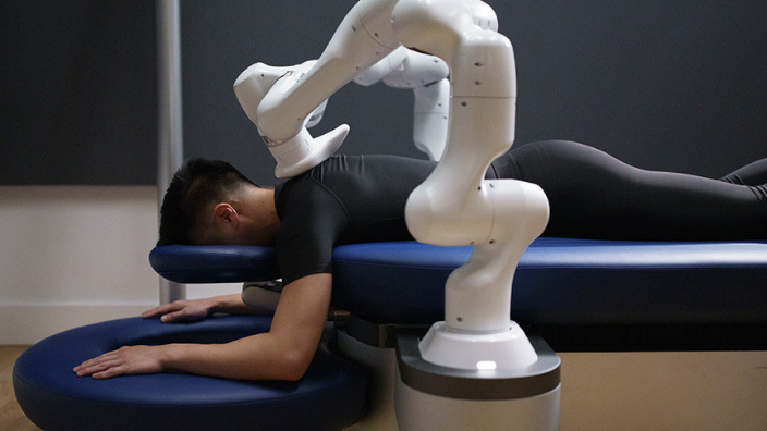 An image of a man receiving a massage from a robot.