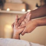 massage therapist massaging client's hand
