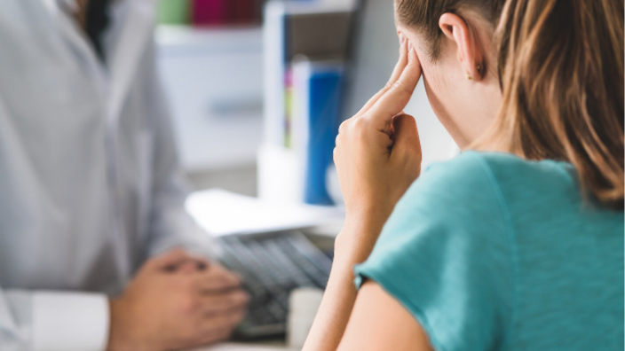 woman at desk looking stressed