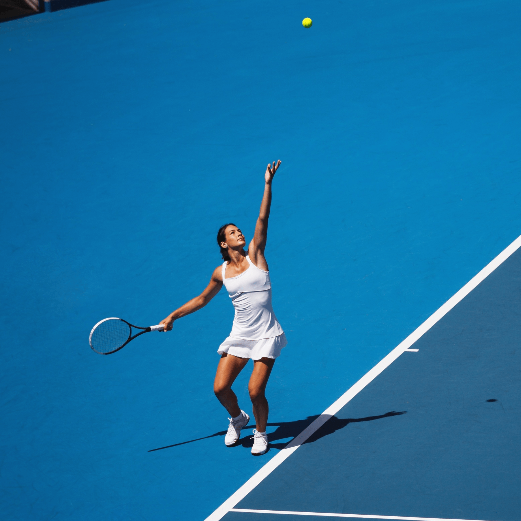 Woman serving a tennis ball