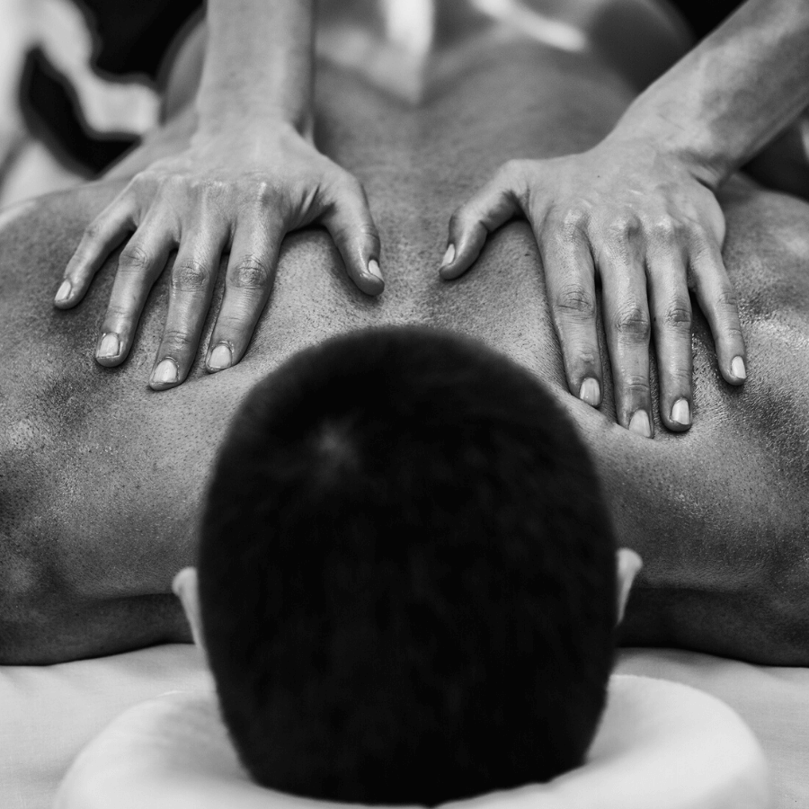 massage therapist hands massaging client's back