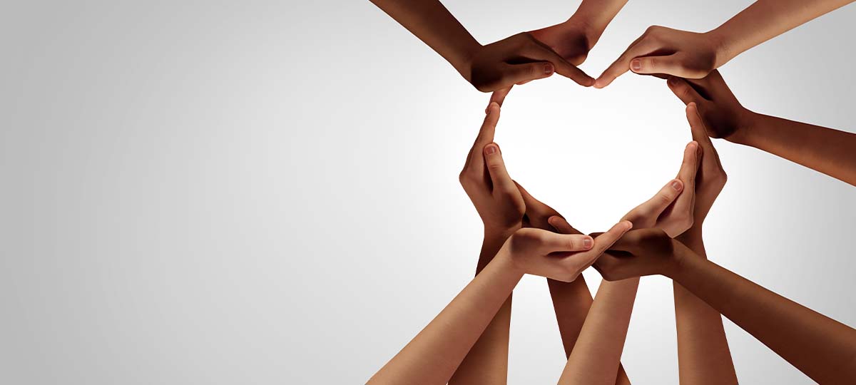 Several hands clasped together making a heart