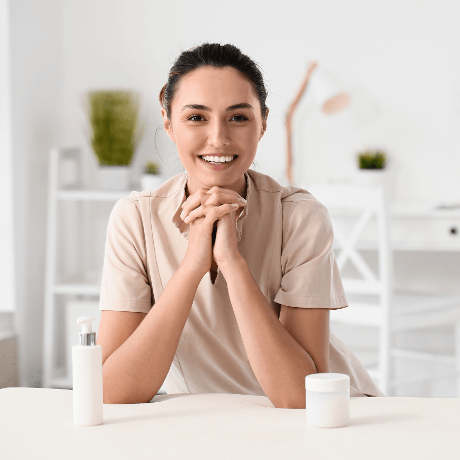 Woman leaning on massage table smiling at the camera