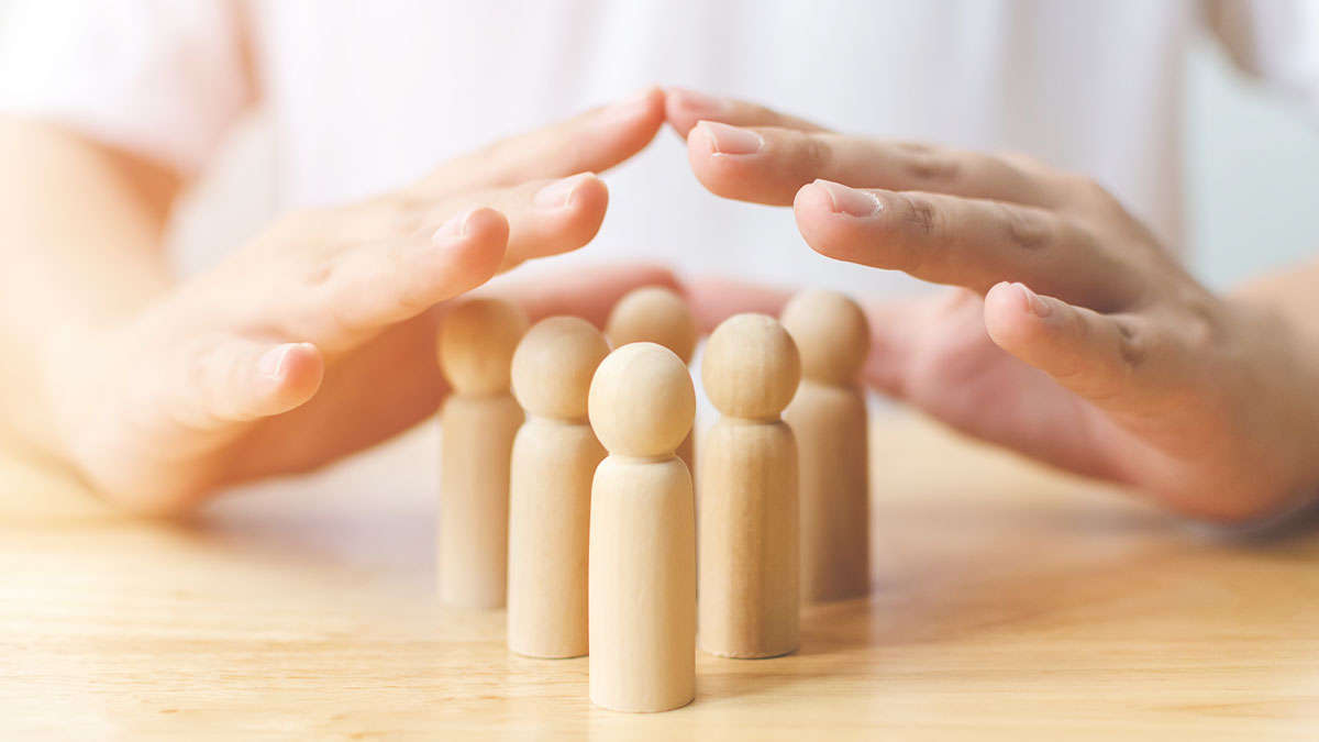 hands protecting pegs representing people