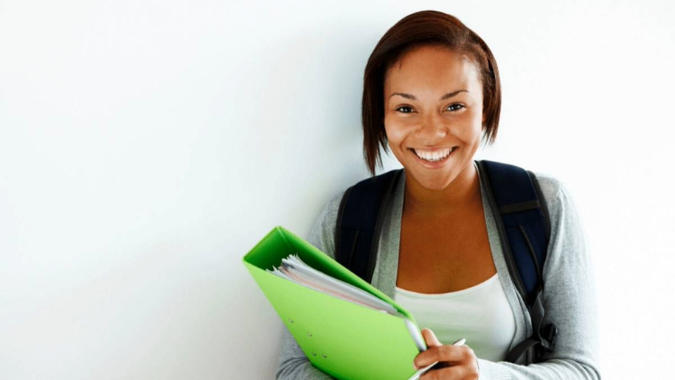 woman in green shirt holding laptop 
