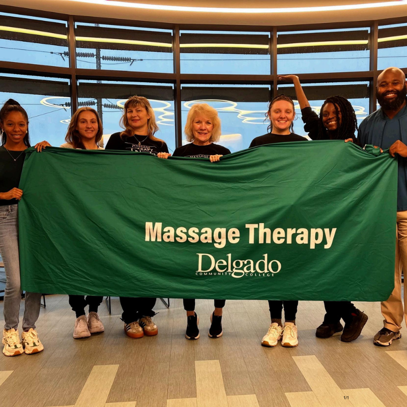 students holding up delgado community college sign